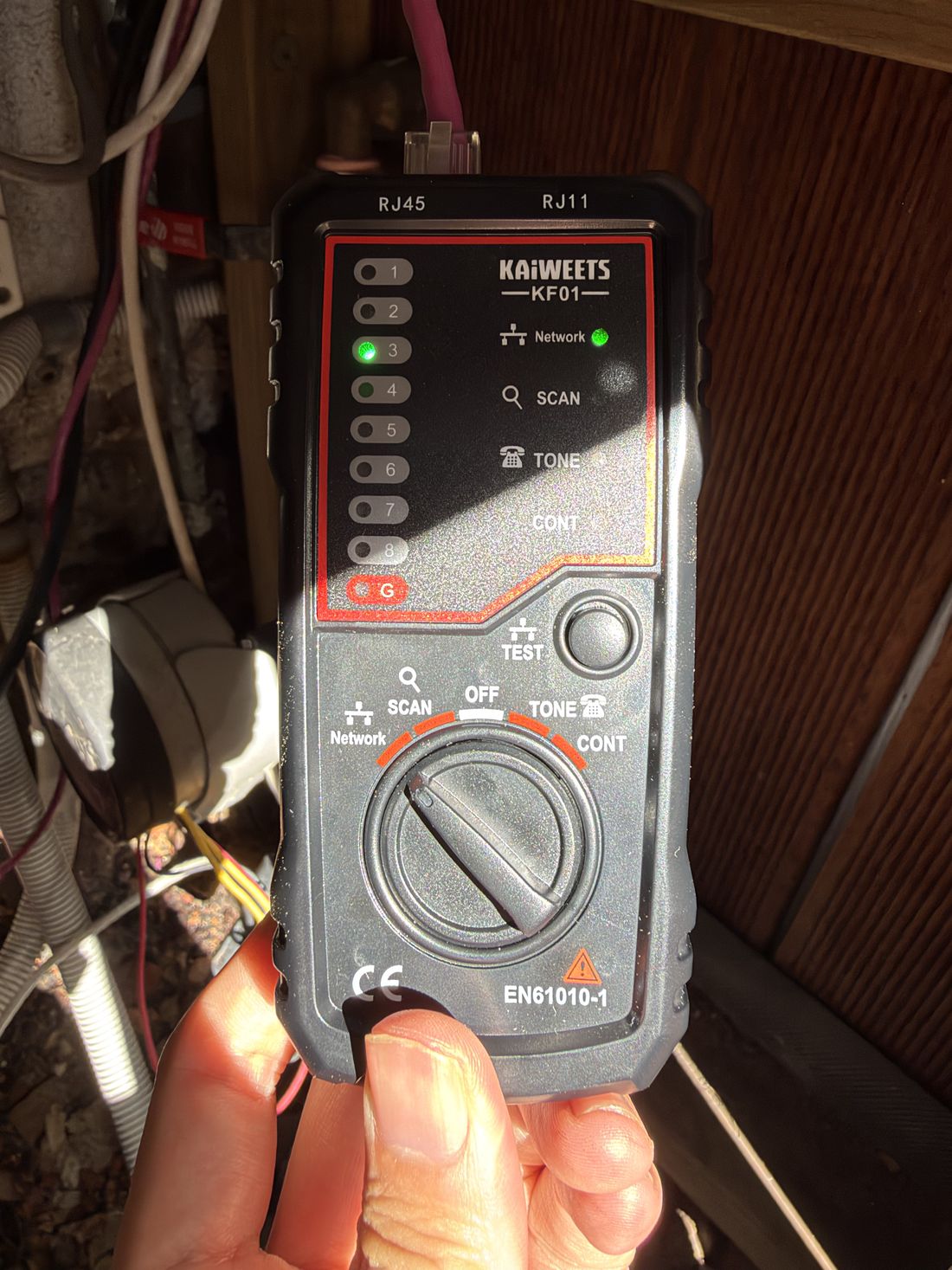 Engineer tracing in-wall cables with a cable tester