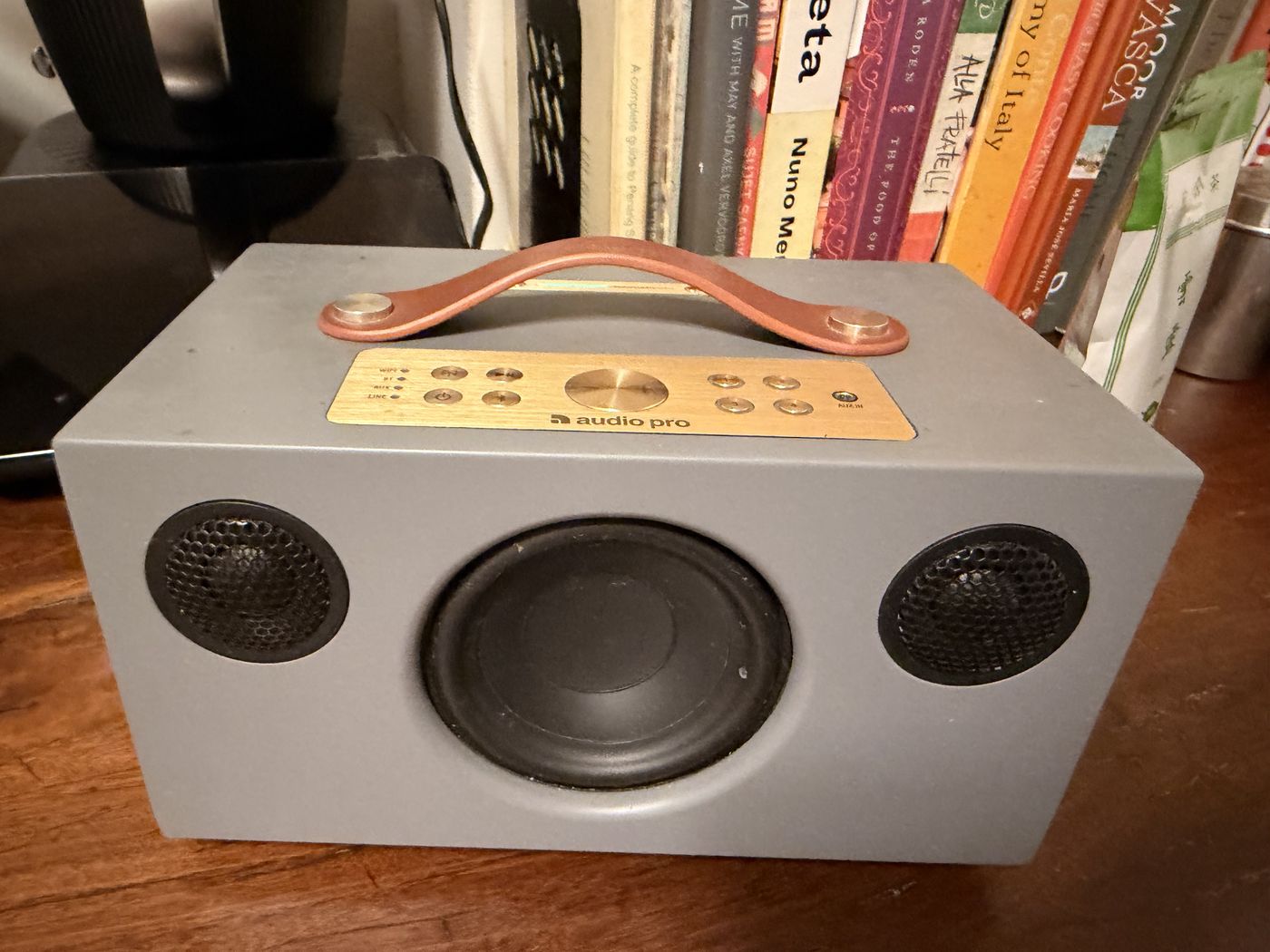 An Audio Pro wireless speaker beside the bookshelf